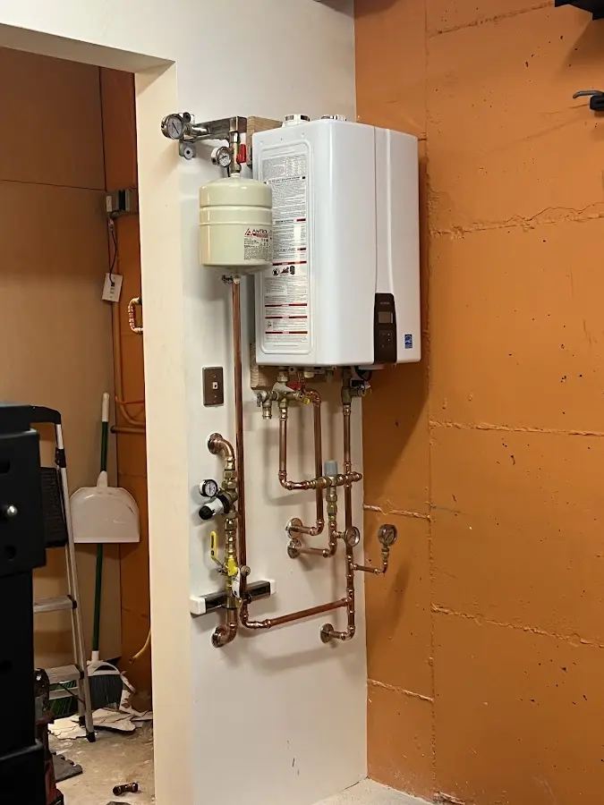 Plumbing technician inspecting water heater connections in Kaplan